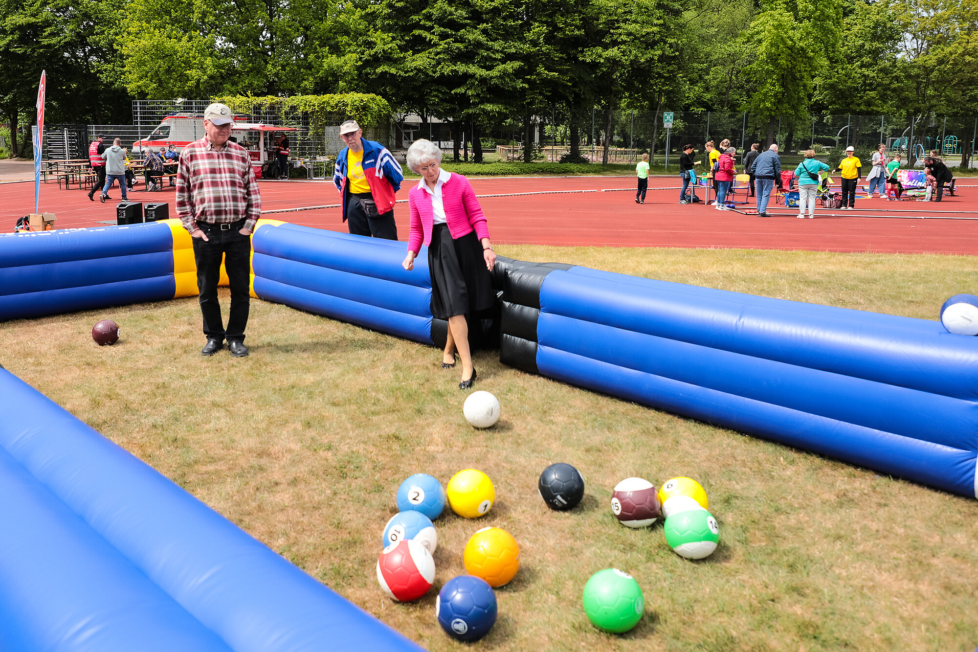 Zwei Menschen stehen in einer Gummiarena und spielen ein Ballspiel